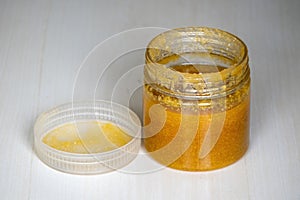 Ghee or clarified butter in a jar on a wooden background. It contains vitamins A, D, E, and K photo