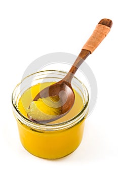 Ghee or clarified butter in jar and wooden spoon isolated photo