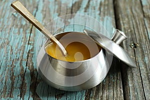 Ghee / Clarified butter on rustic blue background, selective focus photo