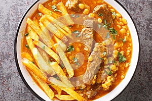Gheimeh or Qeimeh is an Iranian stew consisting of diced mutton or beef, tomatoes, split peas, onion and dried lime, garnished photo