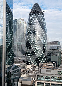 Gherkin Building, 30 St Mary Axe in the City of London financial district, with reflection in adjacent building, London UK