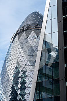 The Gherkin Building at 30 St Mary Axe in the City of London UK, visible behind the Willis building on Lime Street.