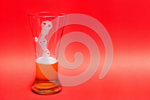 Ghost form of Beer bubbles in glass on red background
