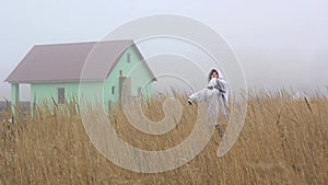 Ghost girl in the fog near an abandoned house