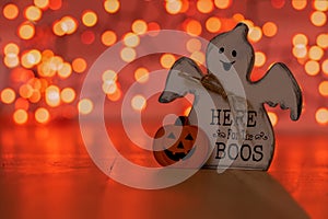 A Ghost That Says Here for the Boos With Orange Bokeh Behind It