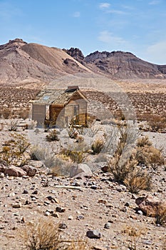 Ghost town abandoned home in desert by mountains