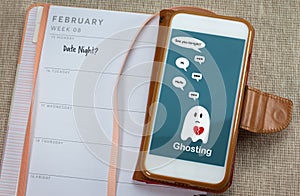 Ghosting on mobile phone on table with diary, Ghosted to cut all communication without explanation photo