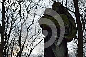 Ghostly old sculpture of woman with child in the cemetery