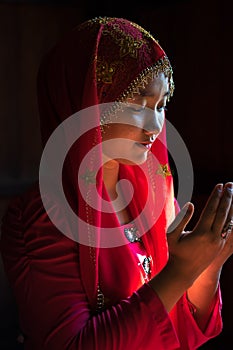 An Giang, Vietnam - Sep 6, 2016: Portrait of Vietnamese muslim girl wearing traditional red dress in a champa village, Khanh Hoan