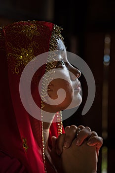 An Giang, Vietnam - Sep 6, 2016: Portrait of Vietnamese muslim girl wearing traditional red dress in a champa village, Khanh Hoan