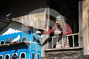 An Giang, Vietnam - Sep 6, 2016: Vietnamese muslim girl feeding pigeons in a champa village, Khanh Hoan district, South Vietnam