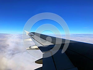 Aeroplane wing over the white cloud sky