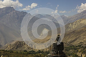 A giant black buddha on top of a mountain observes a Nepali valley very close to Muktinath in the Nepali Himalayas