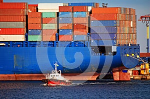 Giant Blue Container Ship and Small Red Tugboat