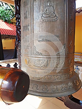 Giant bronze gong and wooden mace. Temple hanging bell Musical instrument Buddhist temple entrance. Eastern faith and religion