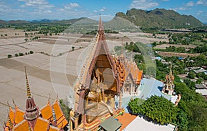 A giant Buddha statue looks out over downtown Thailand at sunset