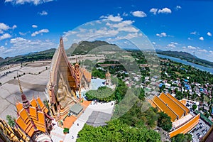 A giant Buddha statue looks out over downtown Thailand at sunset