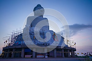 Giant Buddha statue on top of tropical island mountain in asia