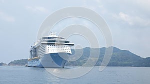 Giant cruise ship docked in the middle of ocean of Patong sea at Phuket under sunny day vacation holiday time. Luxuary Cruise ship