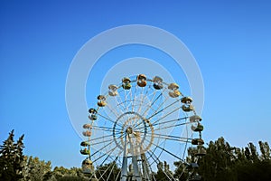 The Giant Ferris Wheel in amusement park. Brightly colored Ferris wheel against the blue sky