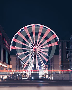 a giant ferris wheel is in an empty street at night