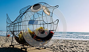 Giant fish shaped trash bin on a beach in Espinho, Portugal