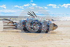 Giant fish shaped waste container at a beach
