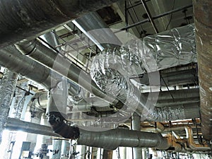 Giant glitter tubes, equipment, cables and piping inside a modern industrial power plant