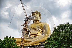 Giant golden buddha statue of Dhammakaya Thep Mongkol Buddha in construction site located at Wat Paknam Bhasicharoen temple