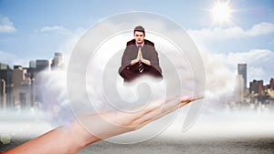 Giant hand presenting businessman doing yoga