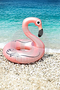 Giant inflated flamingo on a beach with turquois water of Ionian Sea Albania