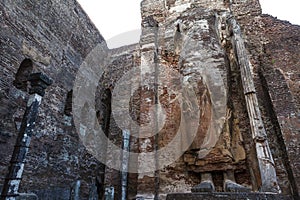 A giant masoned standing Buddha statue without head in a temple in the royal ancient city of Polonnaruwa in Sri Lanka