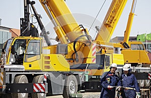 Giant mobile cranes and building workers