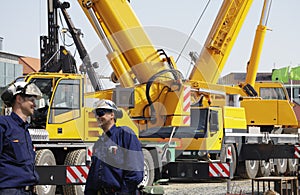 Giant mobile cranes and building workers