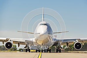 Giant modern civil passenger airliner at airport. Front view of the aircraft. Summer travel concept