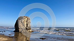 A giant rock sitting at Pismo Beach at San Luis Obispo Bay in California