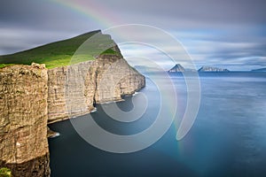 Giant sea cliffs on Faroe Islands with a rainbow