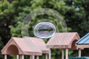 Giant soap bubble floating in air above the playground