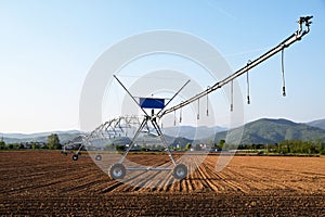 A giant spray sprinkler to irrigate a newly plowed field 604