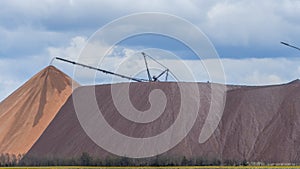 Giant spreader or absetzer machinery. A large dumper on a landfill with potash ore. Extracting potassium salts.