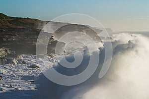 Giant storm seas crash into cliffs