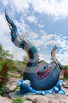 Giant Thai Naga Statue with blue sky clouds in the Phu Manorom Temple,