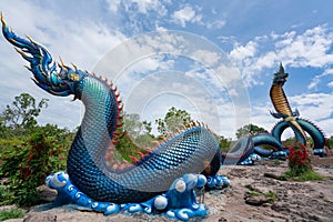 Giant Thai Naga Statue with blue sky clouds in the Phu Manorom Temple,