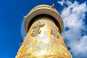 Giant Tibetan Buddhist prayer wheel of Guishan Dafo temple bottom view over blue sky in Dukezong old town Shangri-La Yunnan China