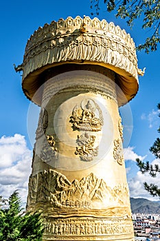 Giant Tibetan Buddhist prayer wheel of Guishan Dafo temple vertical view over blue sky in Dukezong old town Shangri-La Yunnan