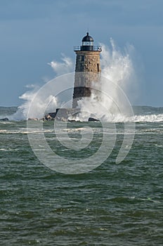 Giant Waves Surround Stone Lighthouse in Maine photo