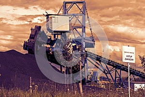 A giant wheel excavator in brown coal mine in the sunset