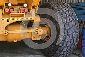 Giant Wheel tire of huge industrial mining truck on repair station. Wheel of yellow auto dumper after tyre replacement.