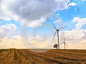 Giant wind turbines on the field under the cloudy sky