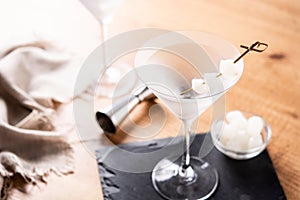 Gibson martini cocktail with onions on wooden table